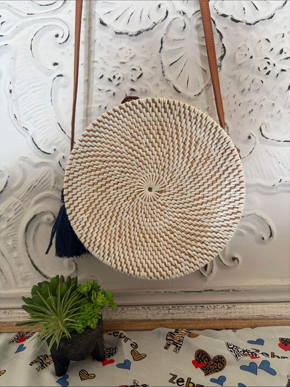 Round Woven Straw Crossbody Bag with Tan Strap and Navy Tassel